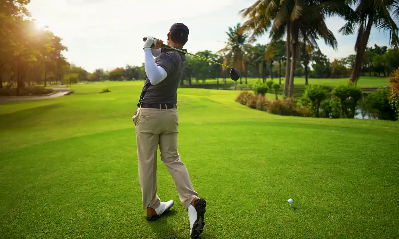 Golfer hitting ball on Florida golf course at sunset